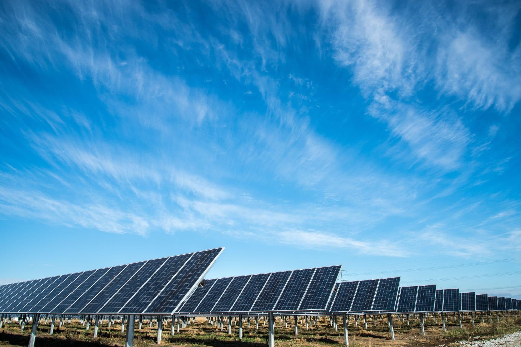 Solar panels set into green grass from above.
