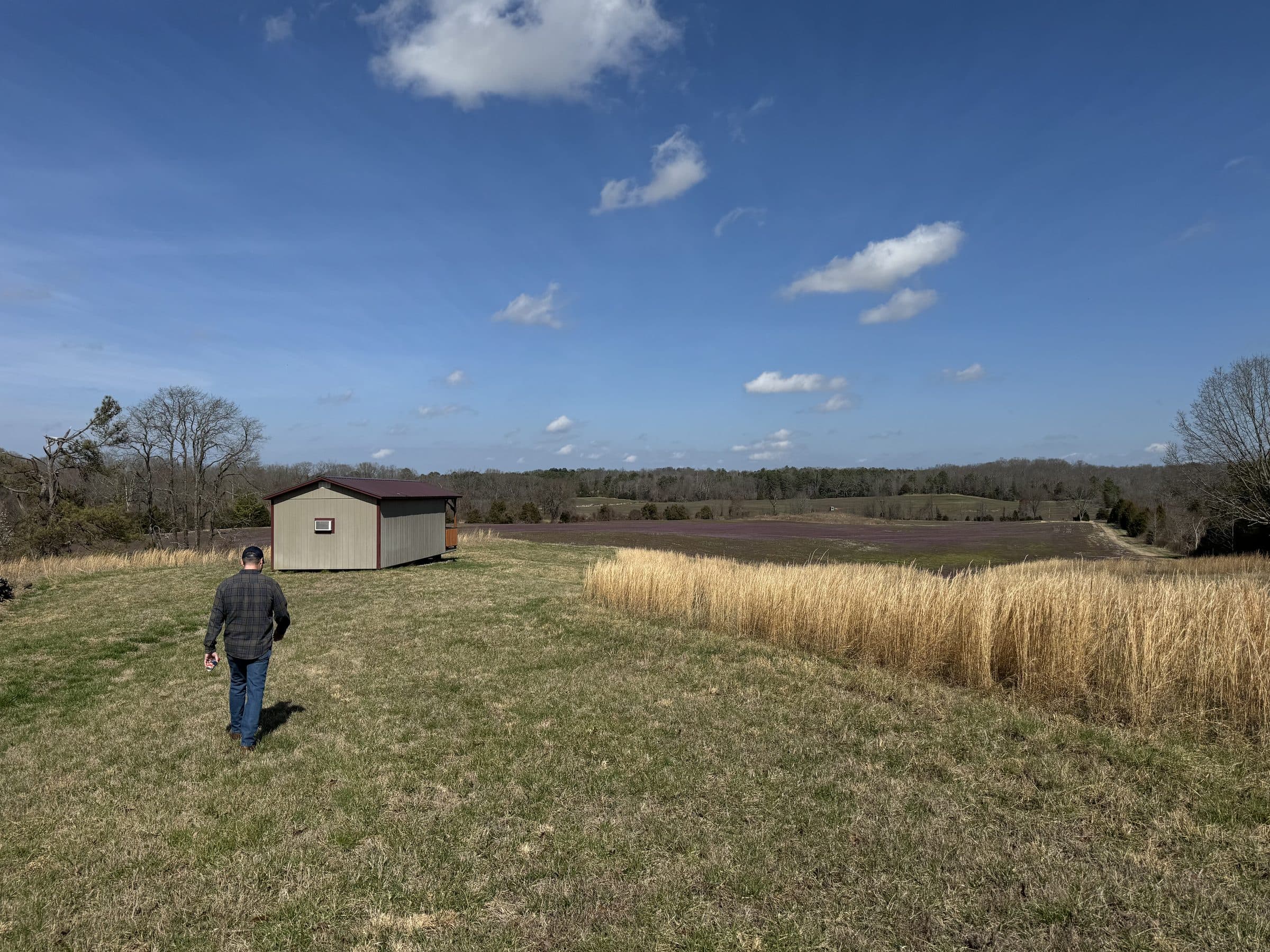 A person walking farmland during a site visit.